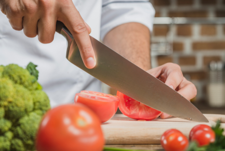 Close-up of chef slicing fresh vegetables